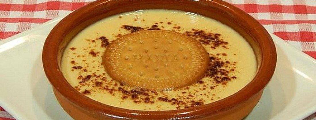 Cuencos de natillas espolvoreadas con canela y una galleta