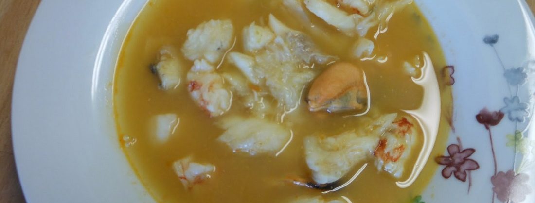Cazuela de barro con sopa de marisco, rape y mejillones